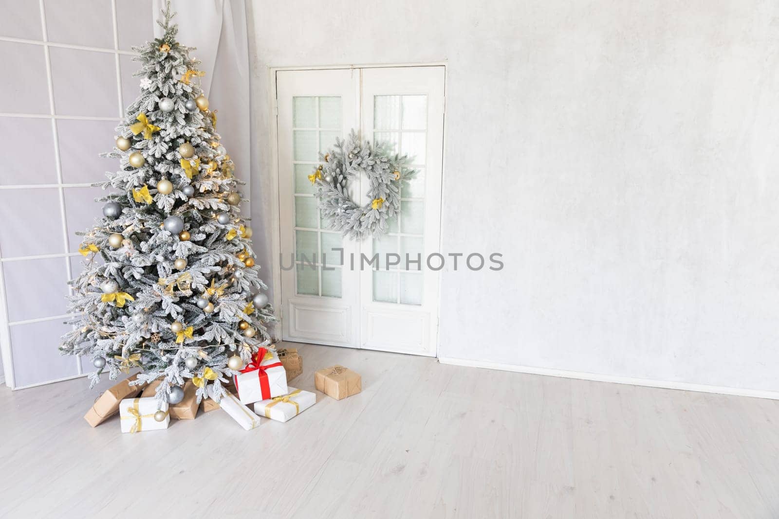 Snow-covered Christmas tree with gifts decorated for the new year in the interior