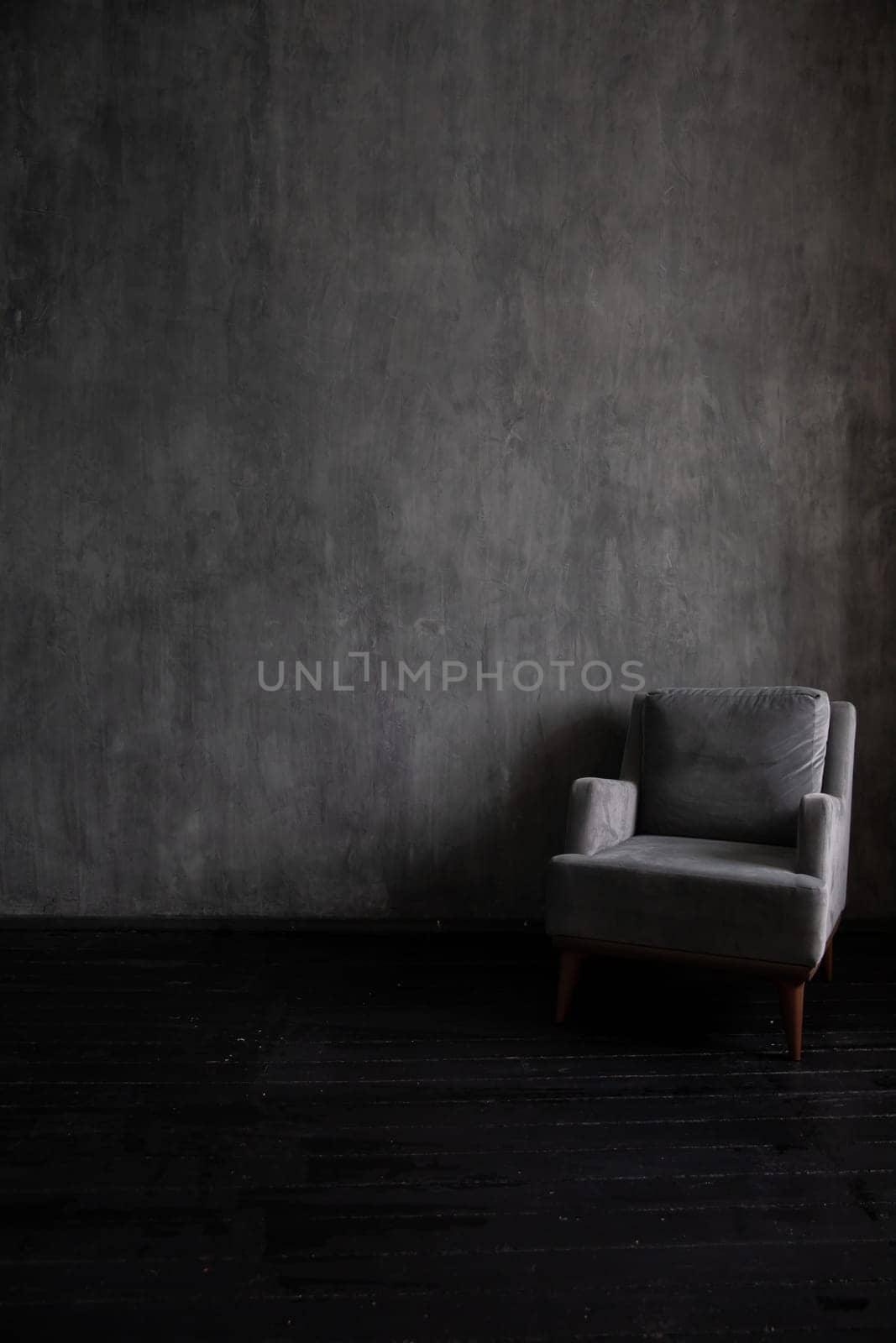 Old vintage armchair in the interior of a dark gray room