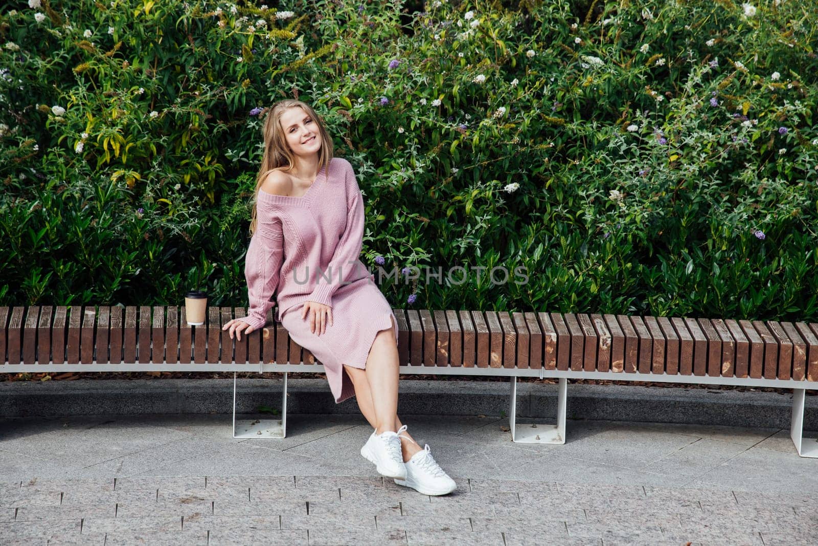 blonde woman in knitted pink dress drinking coffee cocktail