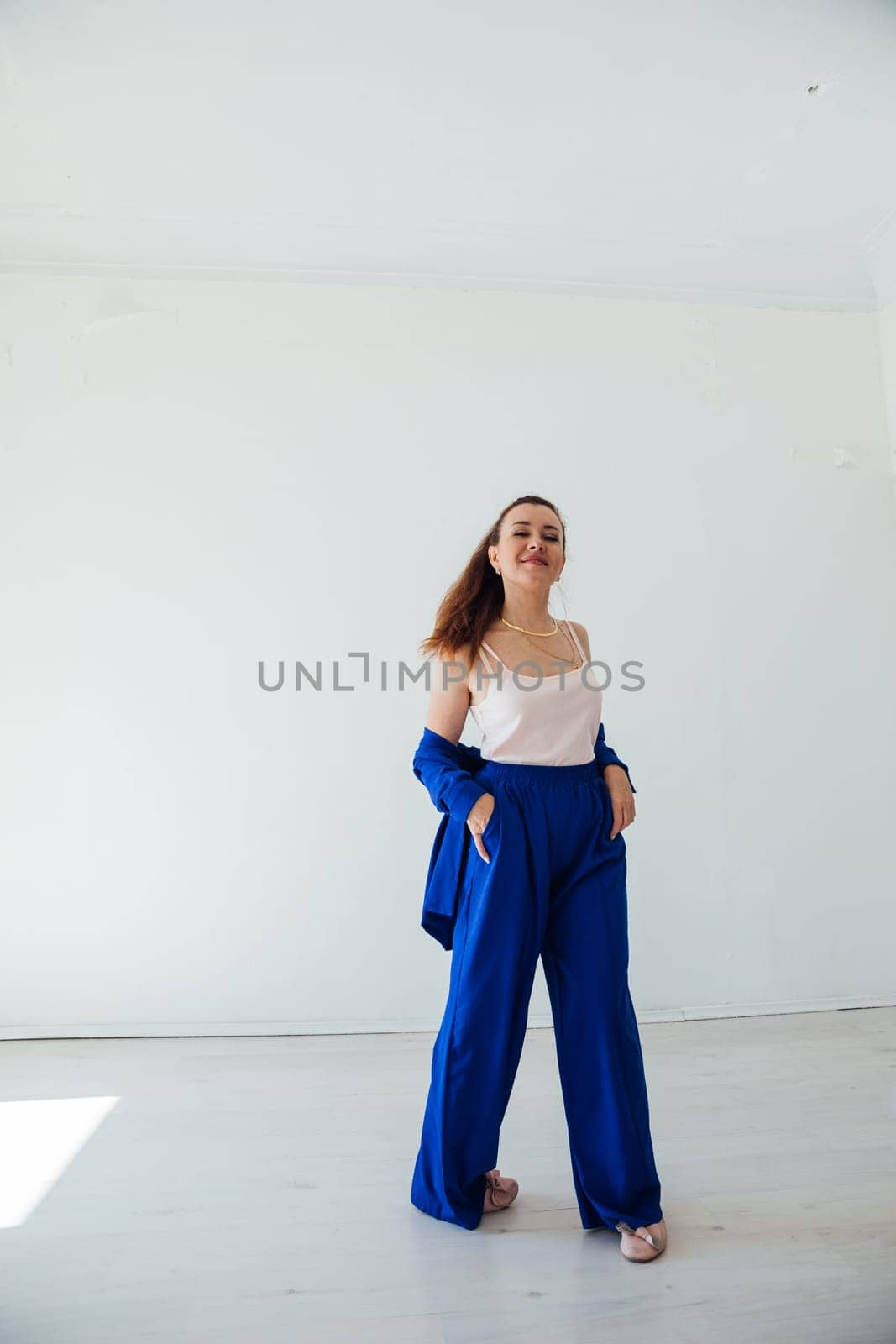 Brunette woman in blue business suit smiling on white background