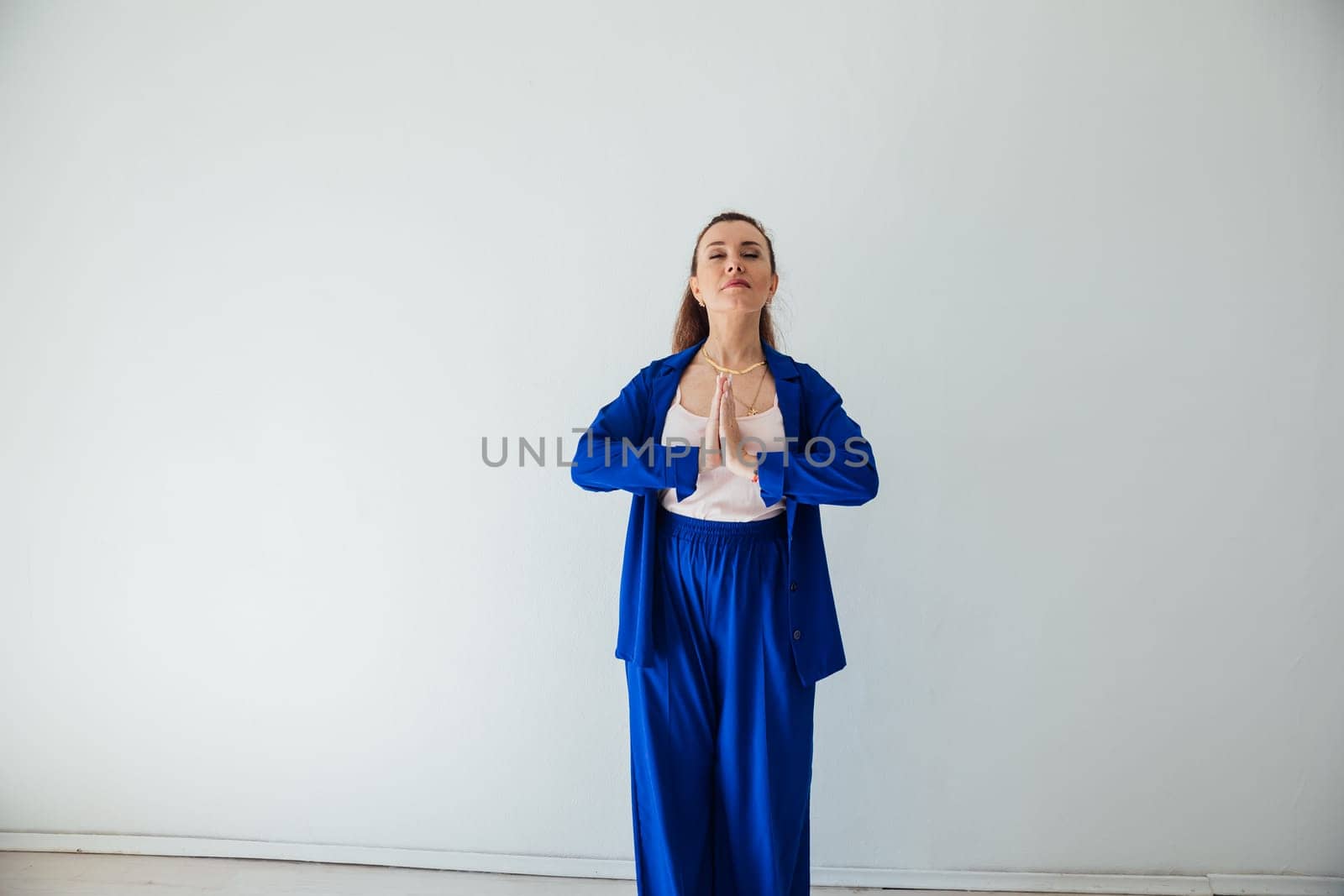 Brunette woman in blue business suit praying