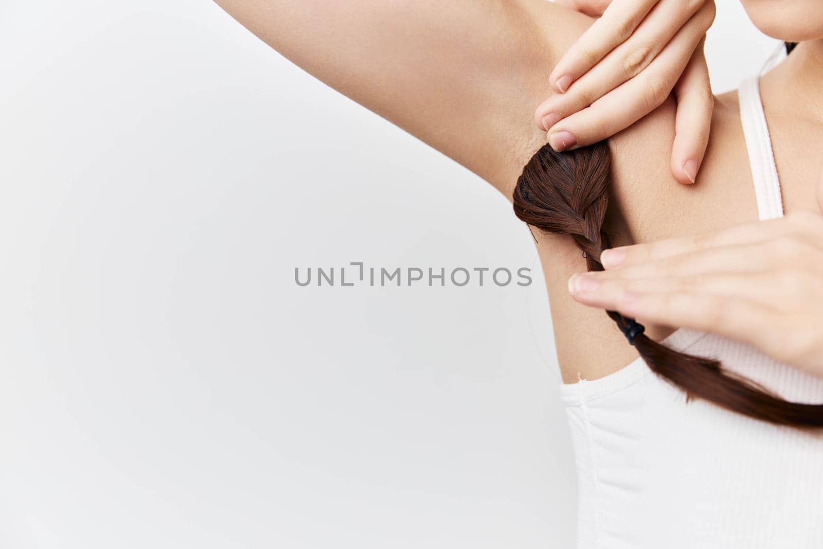 Close up of a woman styling her hair, showcasing an aesthetic of personal grooming and care The image highlights the connection between beauty and confidence with a clean background