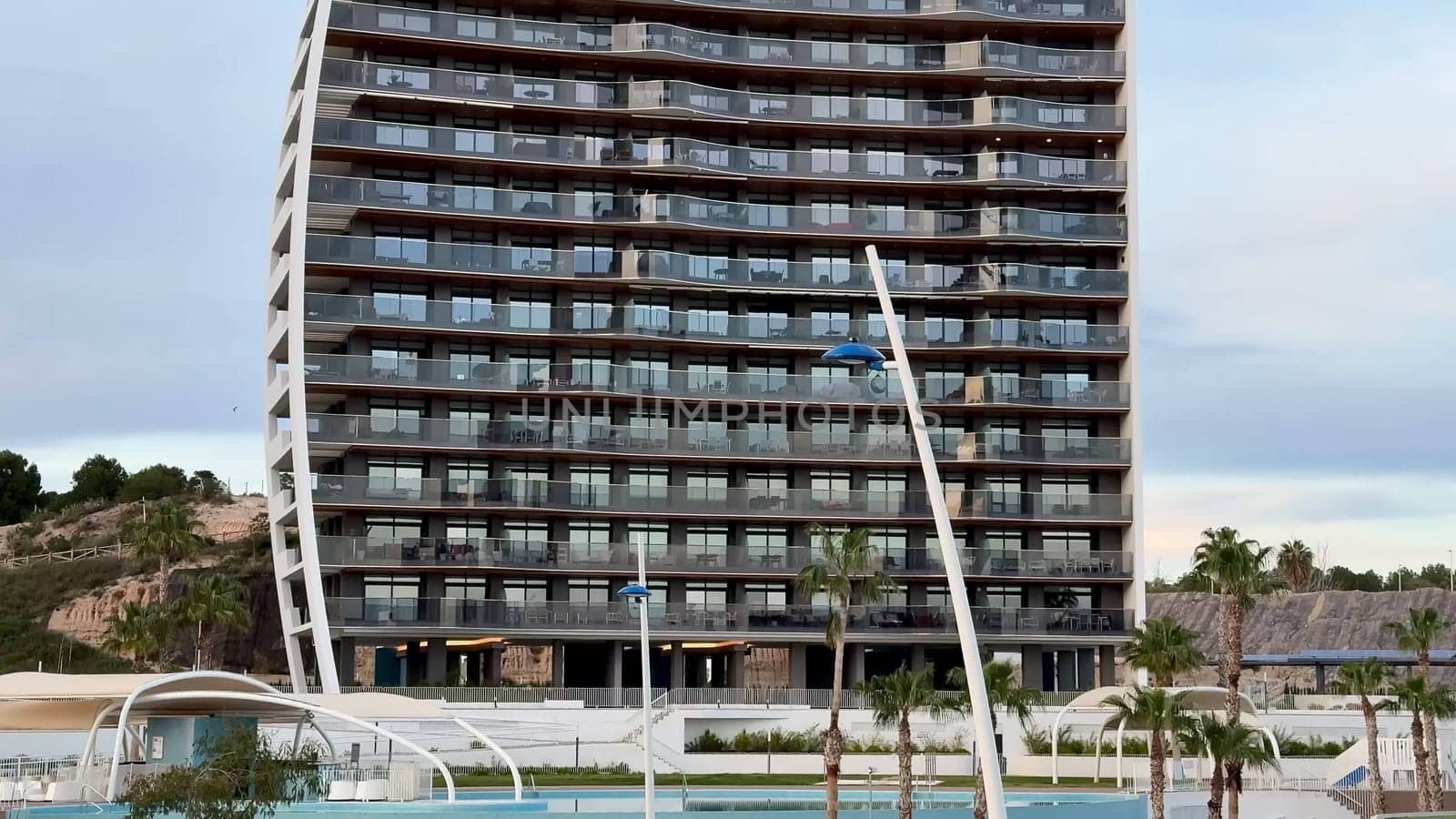 An impressively striking modern building showcasing a distinctive curved facade complemented by elegant balconies