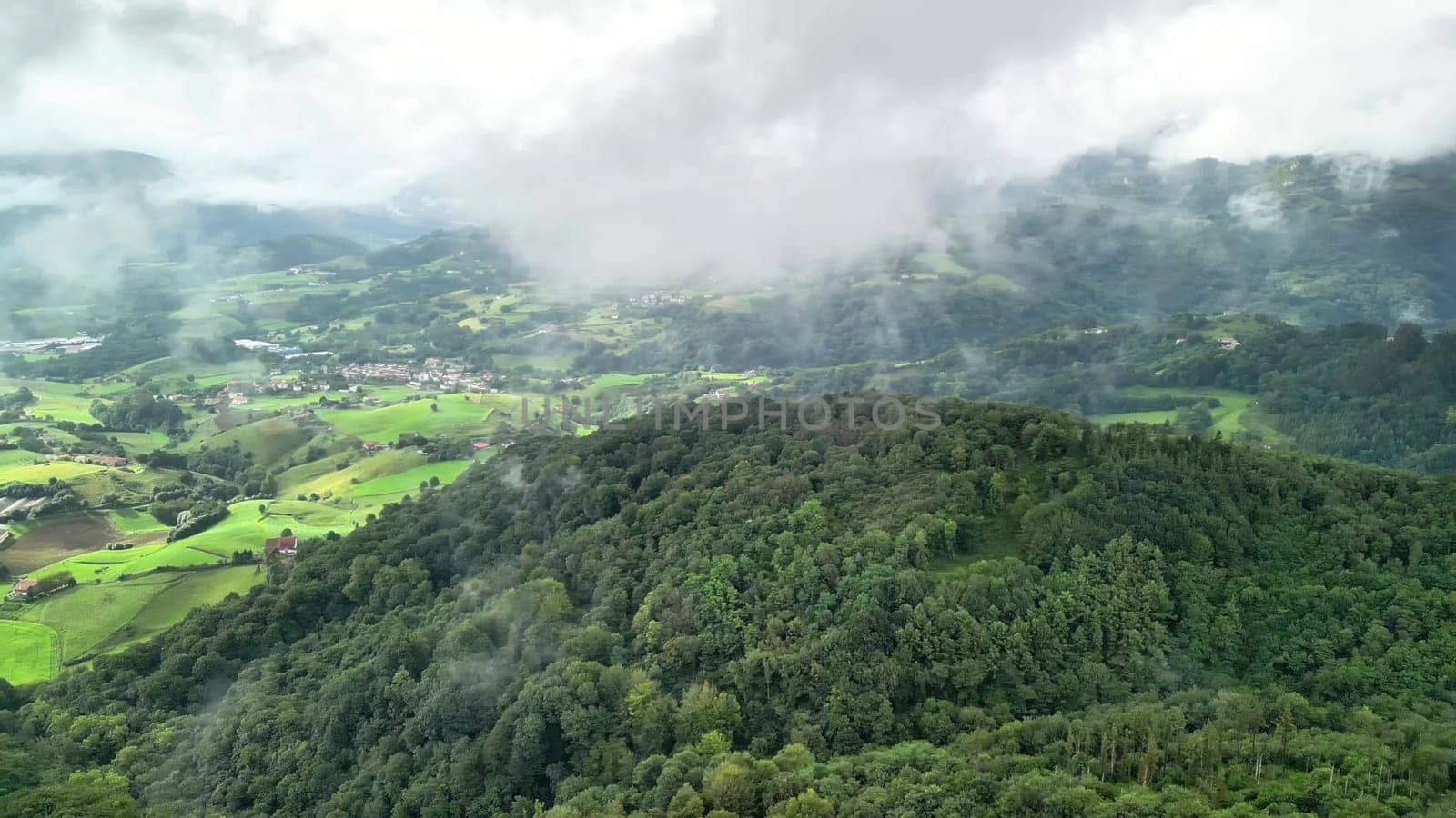 A stunning aerial view showcasing vibrant green hills, fluffy clouds, and beautiful tranquil rural scenery
