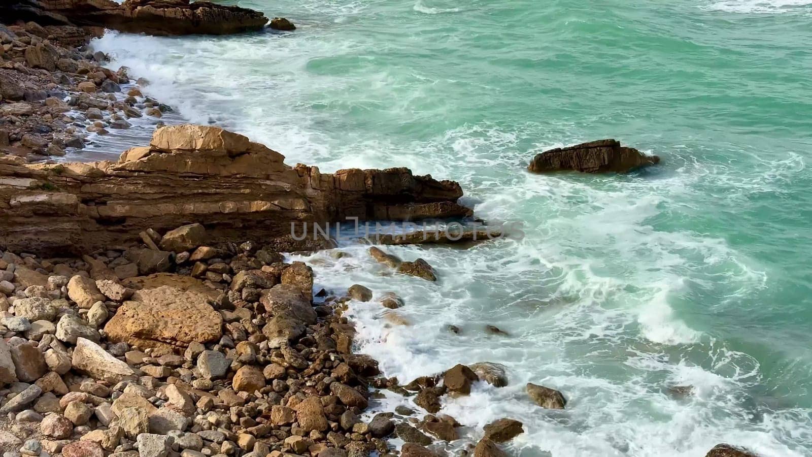 Experience stunning views of powerful waves crashing against the rocky shoreline, capturing natures serenity
