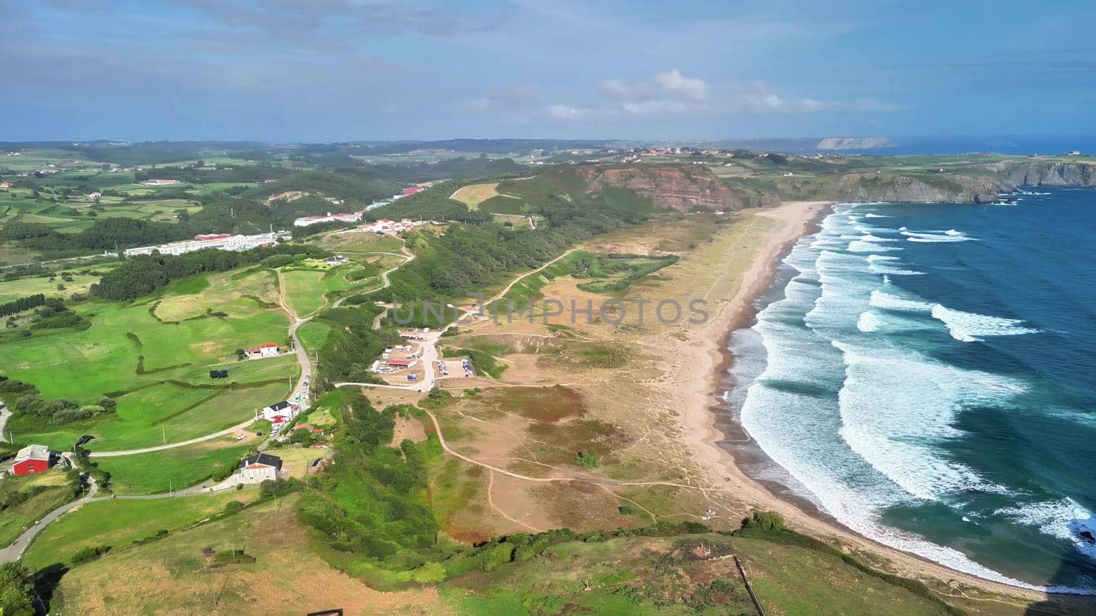 A breathtaking aerial shot captures a vibrant and colorful coastal landscape combined with rich, lush greenery