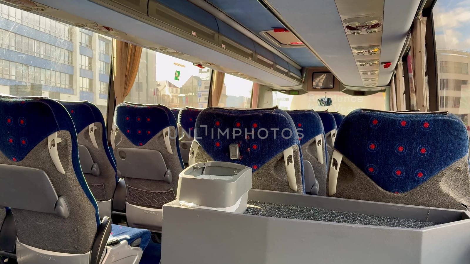 A spacious and inviting view of a contemporary bus interior featuring plush, comfortable seats and large windows