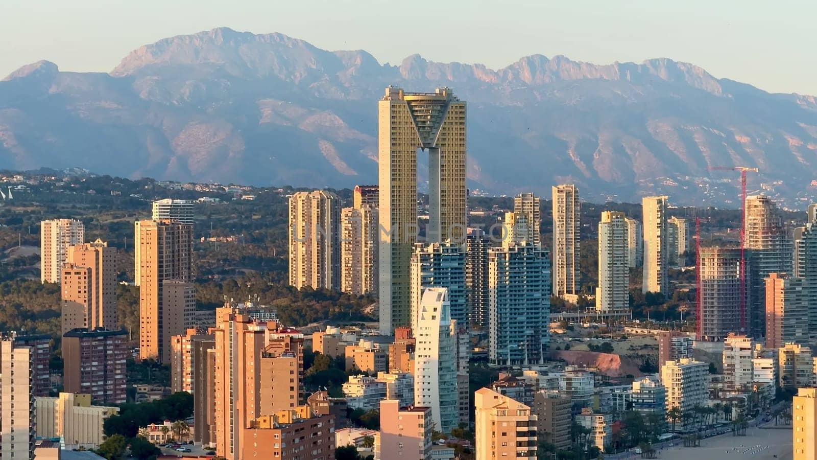 A breathtaking and stunning skyline that beautifully captures urban architecture along with scenic mountains at sunset
