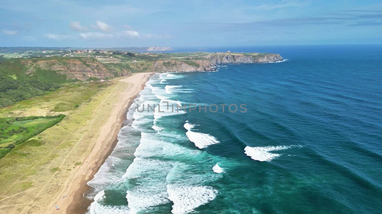A breathtaking aerial view showcasing the stunning crashing waves along a tranquil and serene coastal landscape