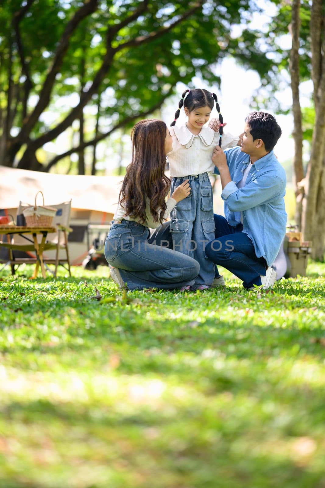 Family having fun at a campsite with tents in the background.