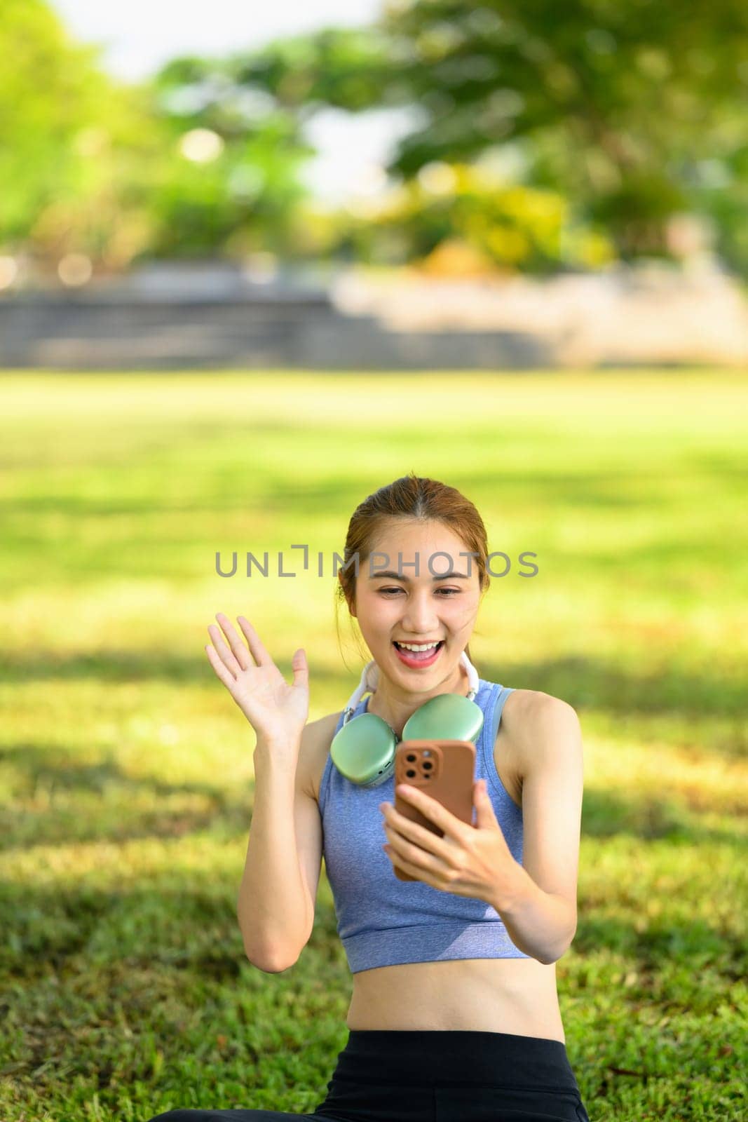 Happy woman chatting on a smartphone outdoors after exercising.