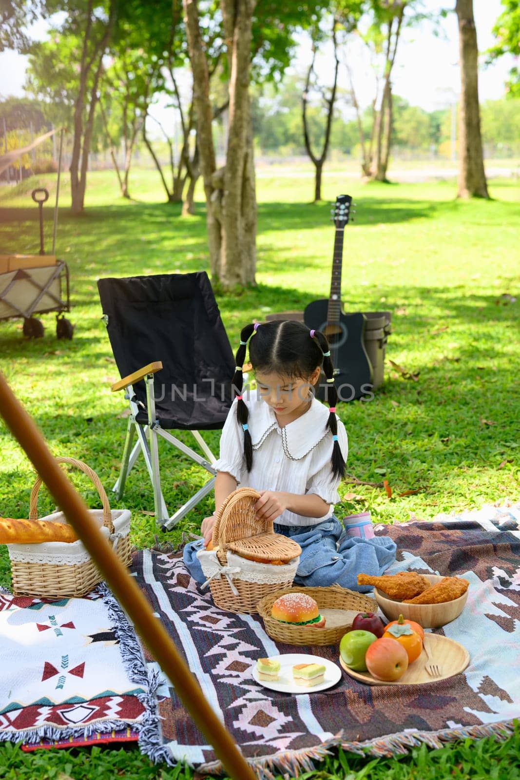 Cheerful asian girl enjoying outdoor adventure at a campsite.