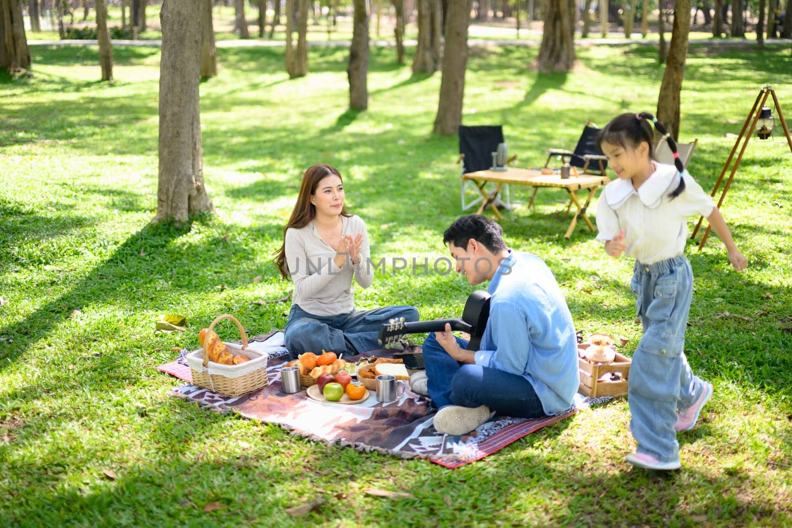 Family having fun at a campsite with tents in the background.