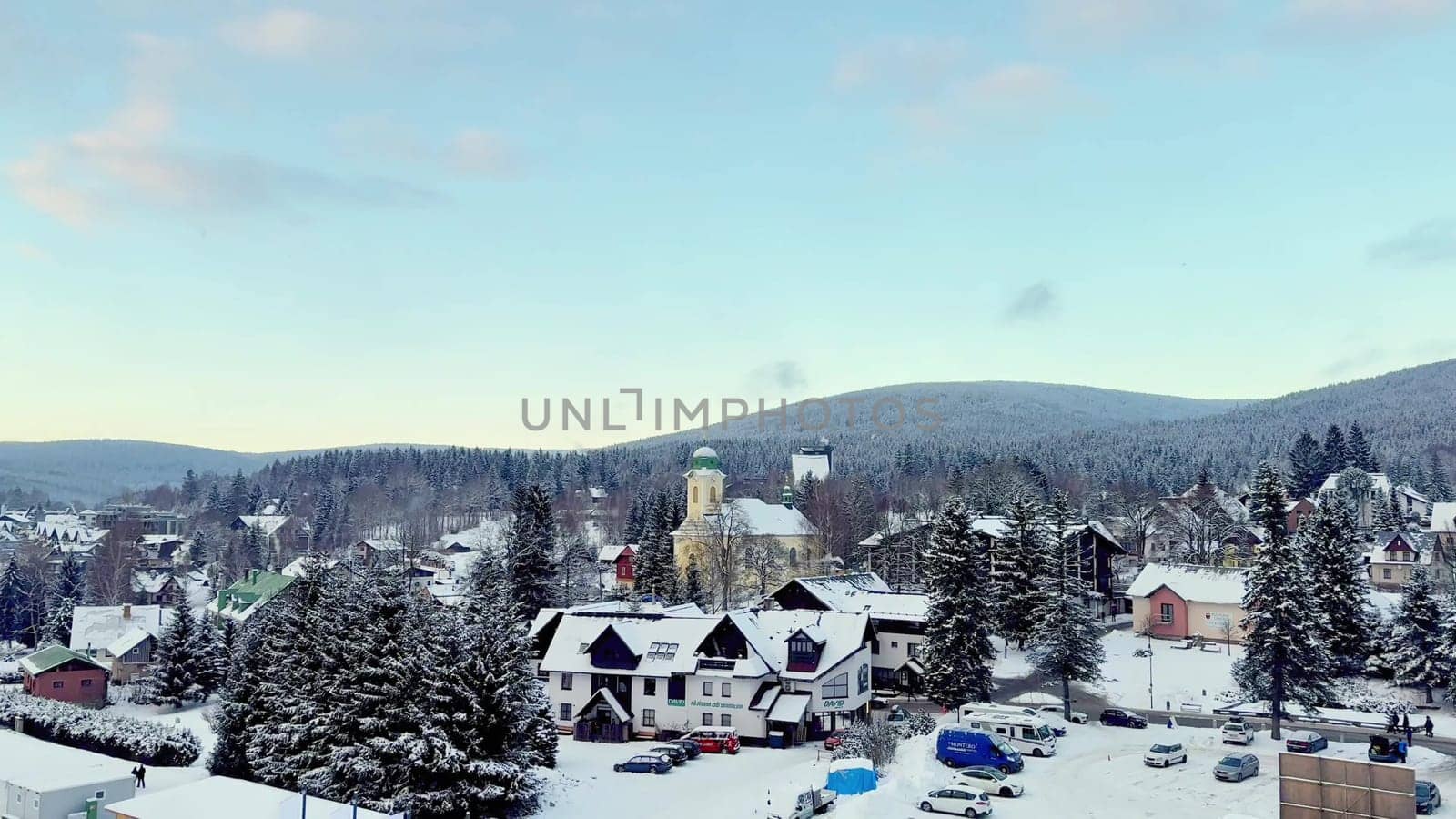 A picturesque winter scene of a charming quaint village entirely blanketed in fresh snow beneath clear blue skies