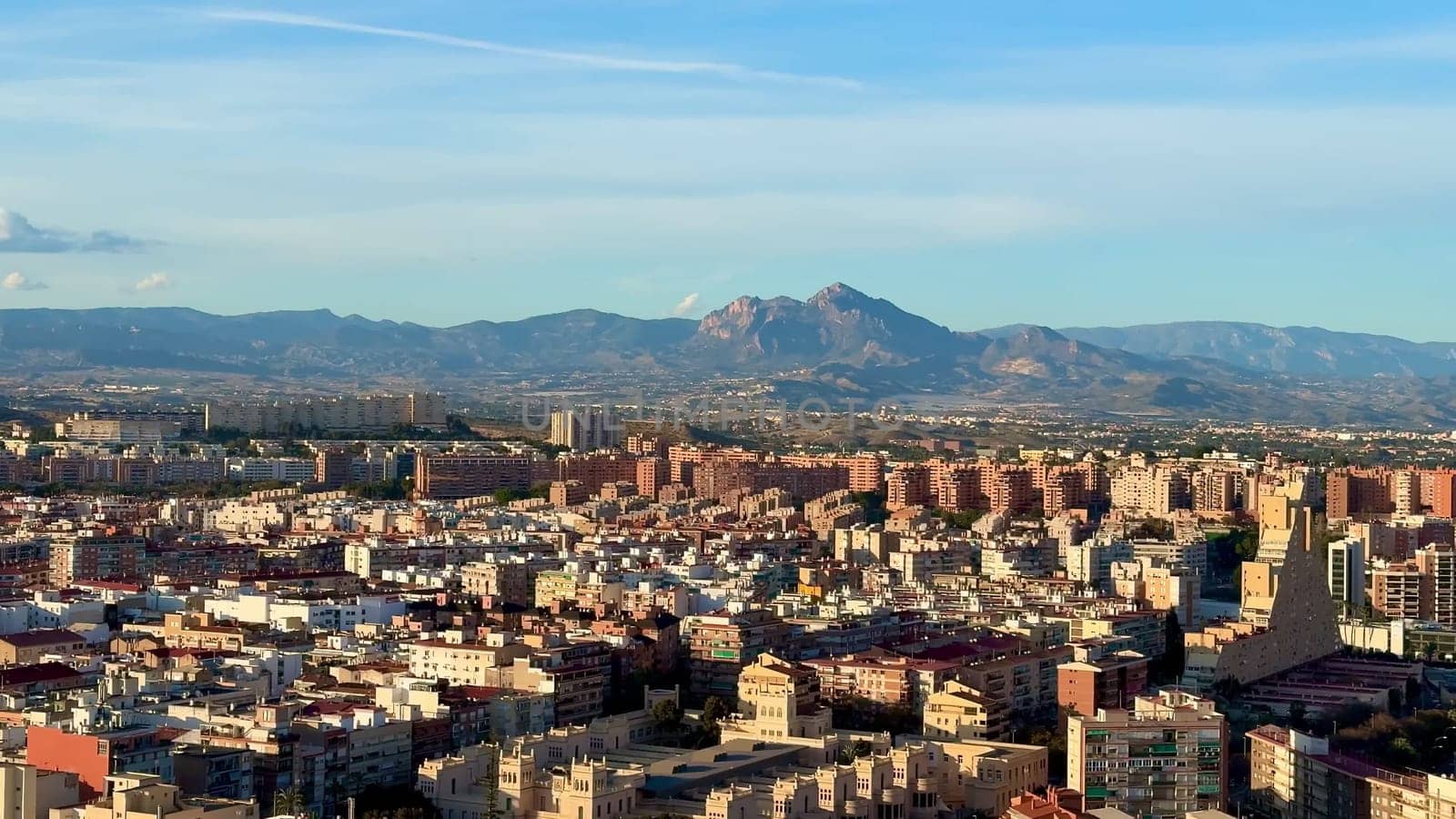 A breathtaking, stunning aerial view highlighting a vibrant cityscape accompanied by majestic nearby mountains