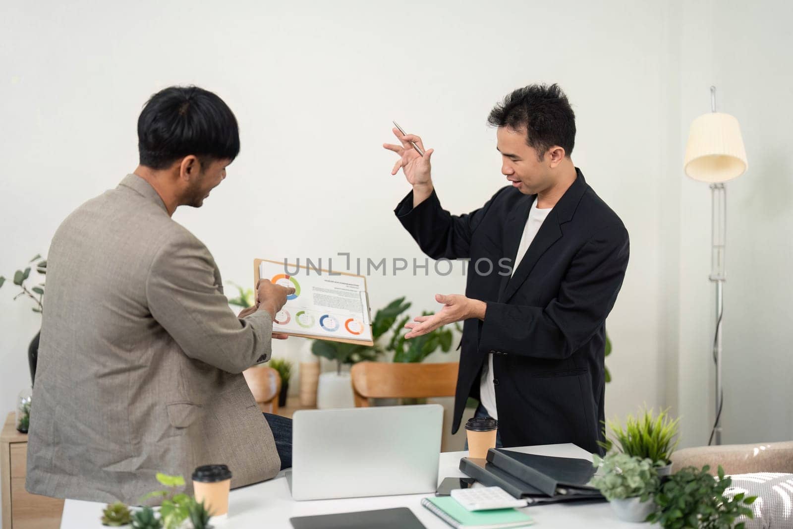 Two professionals analyze performance metrics displayed on a chart, discussing insights and strategies for improvement in a collaborative environment.