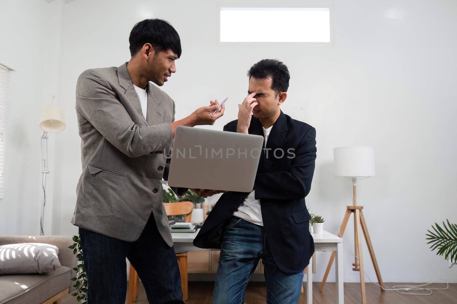 Two colleagues engage in a heated discussion about a project issue, expressing frustration and seeking a resolution in a contemporary workspace.