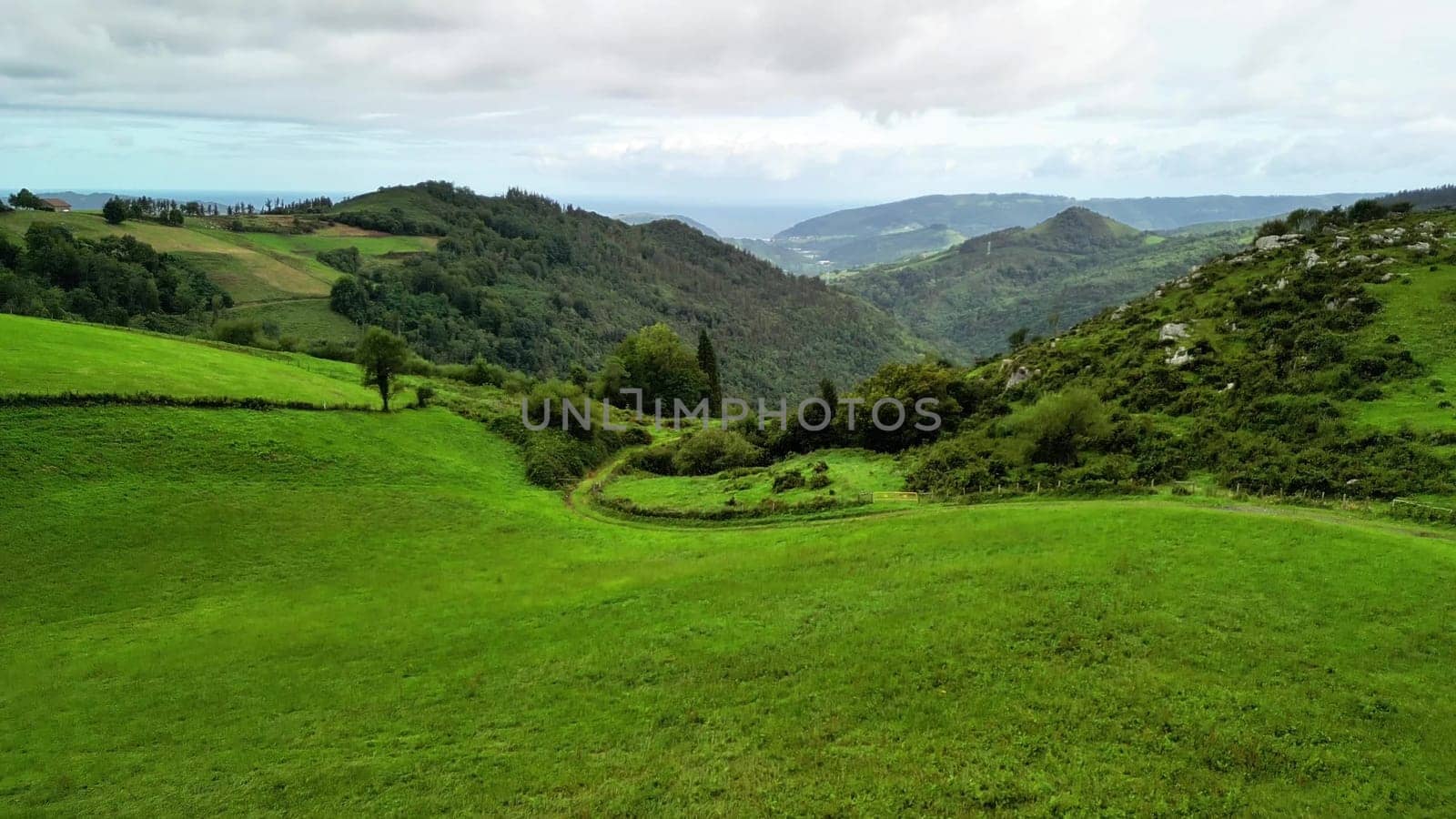 A breathtakingly picturesque view showcases the lush green hills and serene valleys within a tranquil landscape