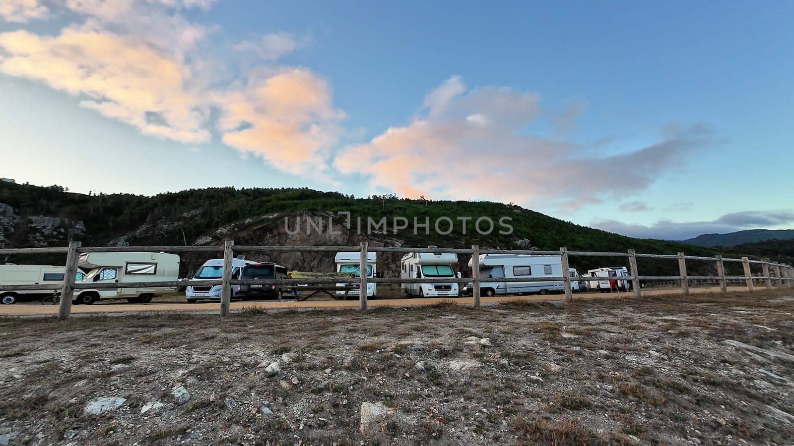 A beautiful and picturesque scene depicting RVs parked gracefully beside a scenic hillside under a bright, vibrant sky
