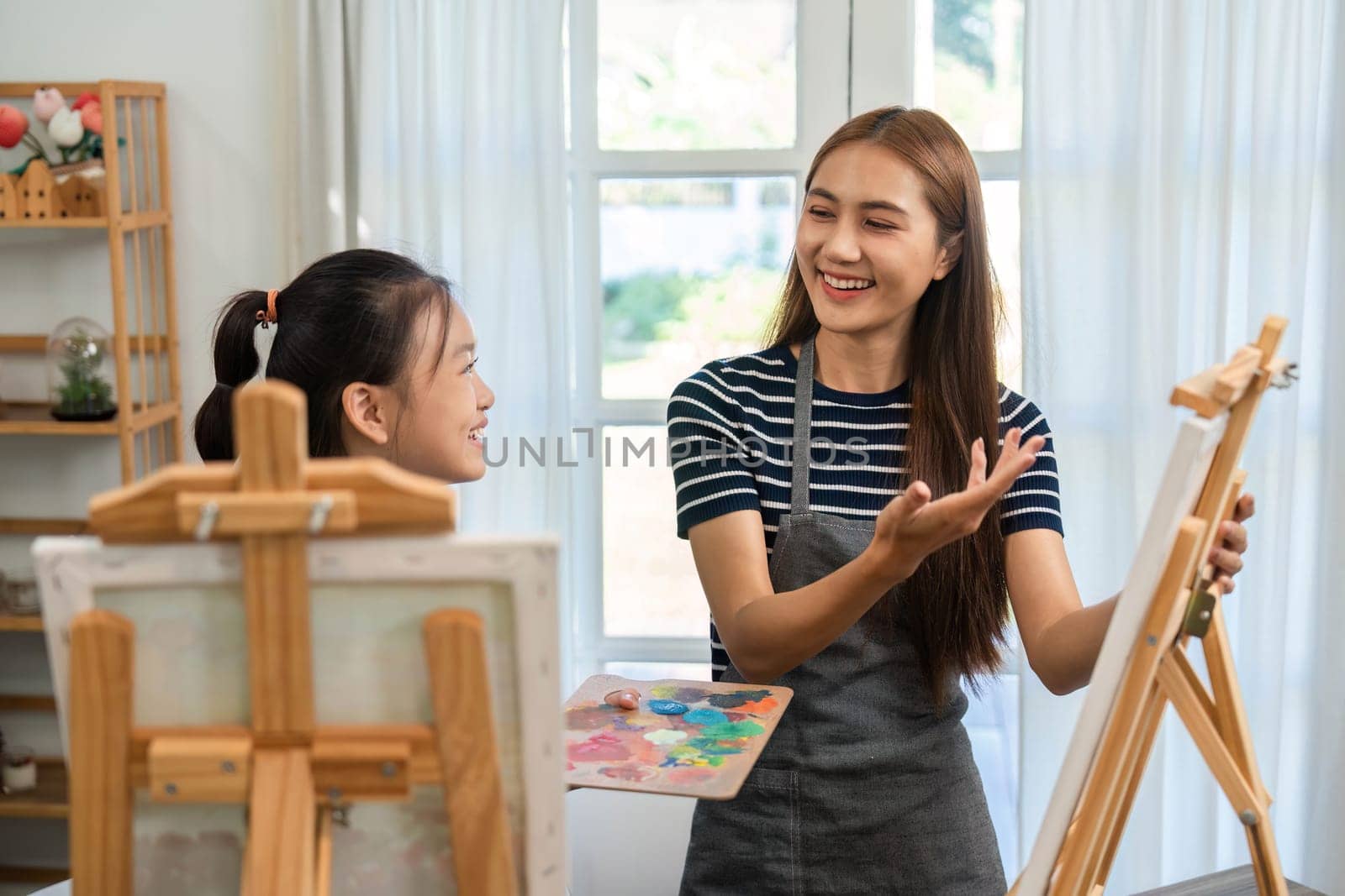 A vibrant scene of a mother and daughter enjoying painting together, fostering creativity and love in their family time.