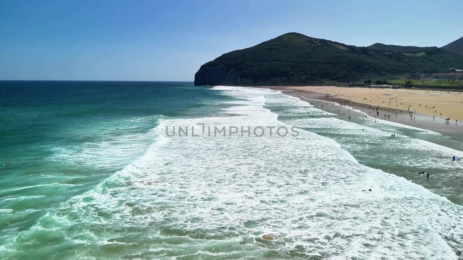 A breathtaking beach view showcasing gorgeous waves, a beautiful shoreline, and sunbathers enjoying a lovely day