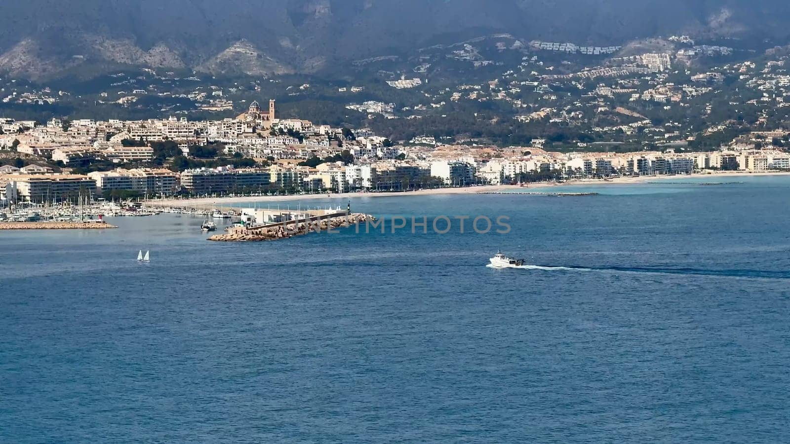 A breathtaking scene of a vibrant coastal city soaking up the beautiful sunlight along the idyllic Mediterranean Sea