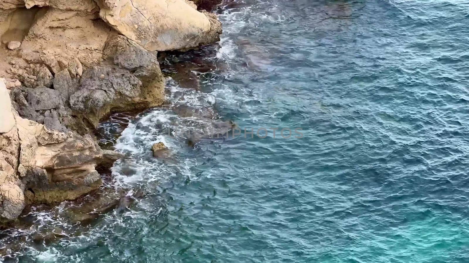 A rugged rocky coastline meets tranquil ocean waters, showcasing natures stunning beauty and allure