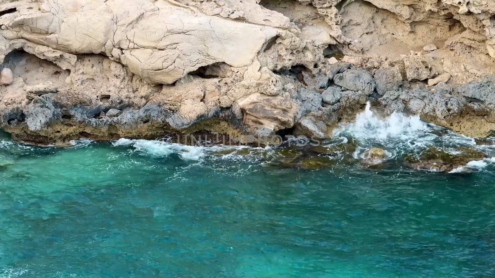 The rocky coastline has clear turquoise waters, perfect for capturing stunning nature and landscape visuals