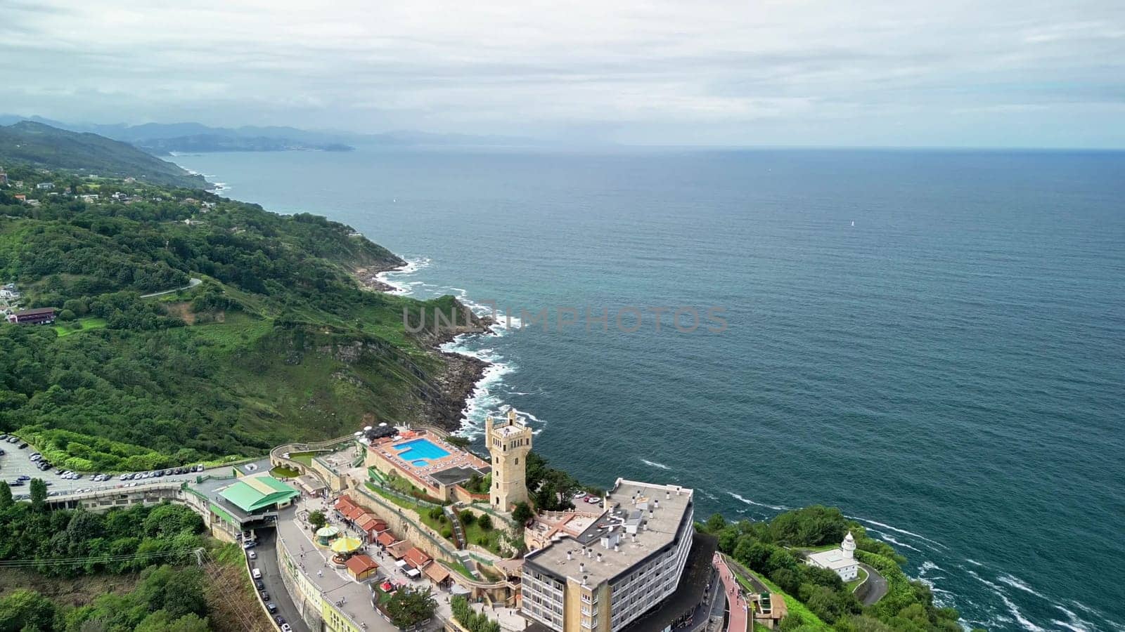 A breathtaking aerial view of a stunning coastal resort surrounded by lush greenery and the vast ocean