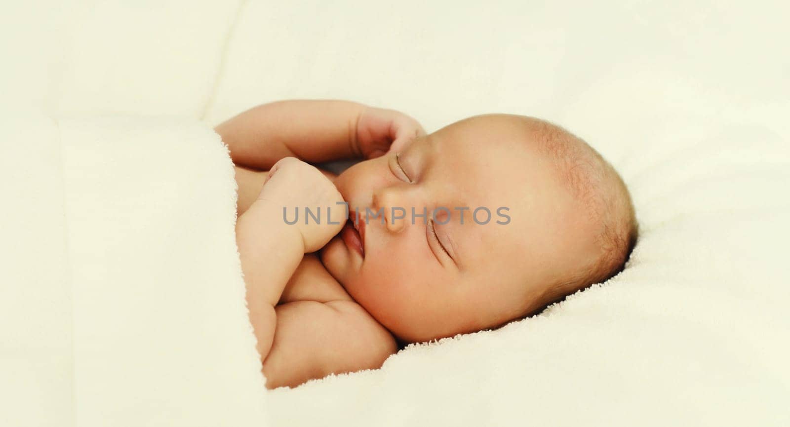 Close up portrait of sweet baby, infant sleeping lying on white bed at home