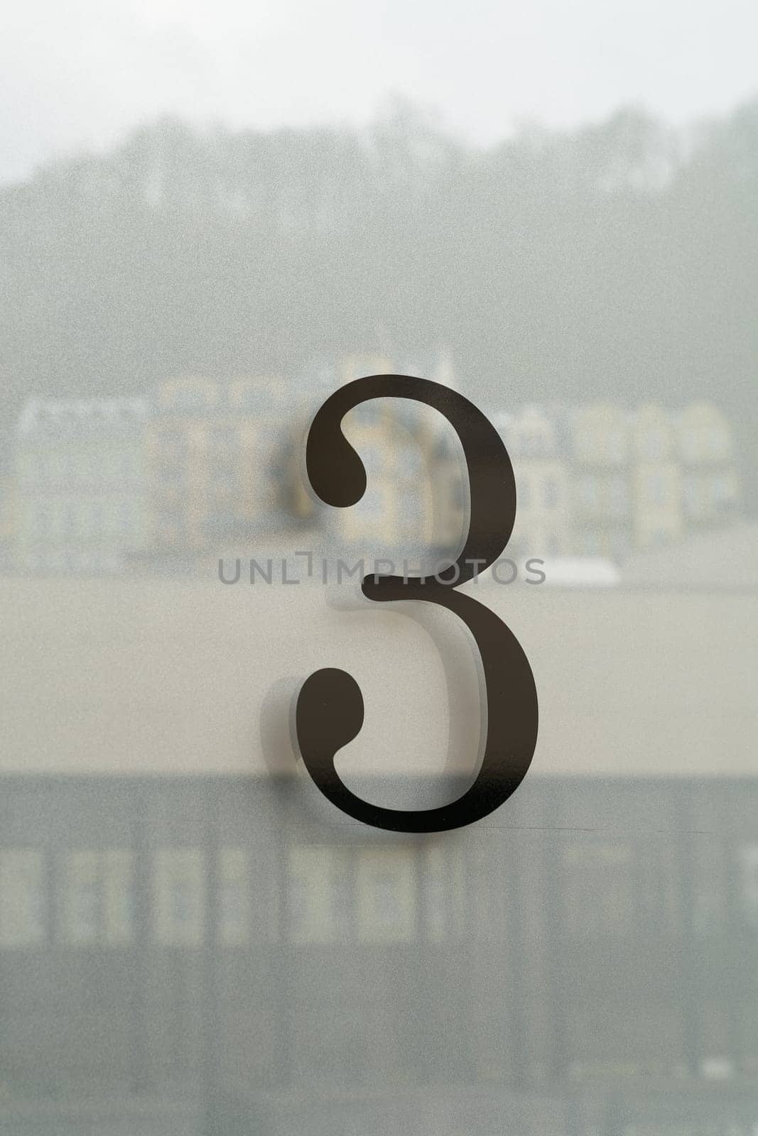 the house number 3 three on the glass of the front door of a house