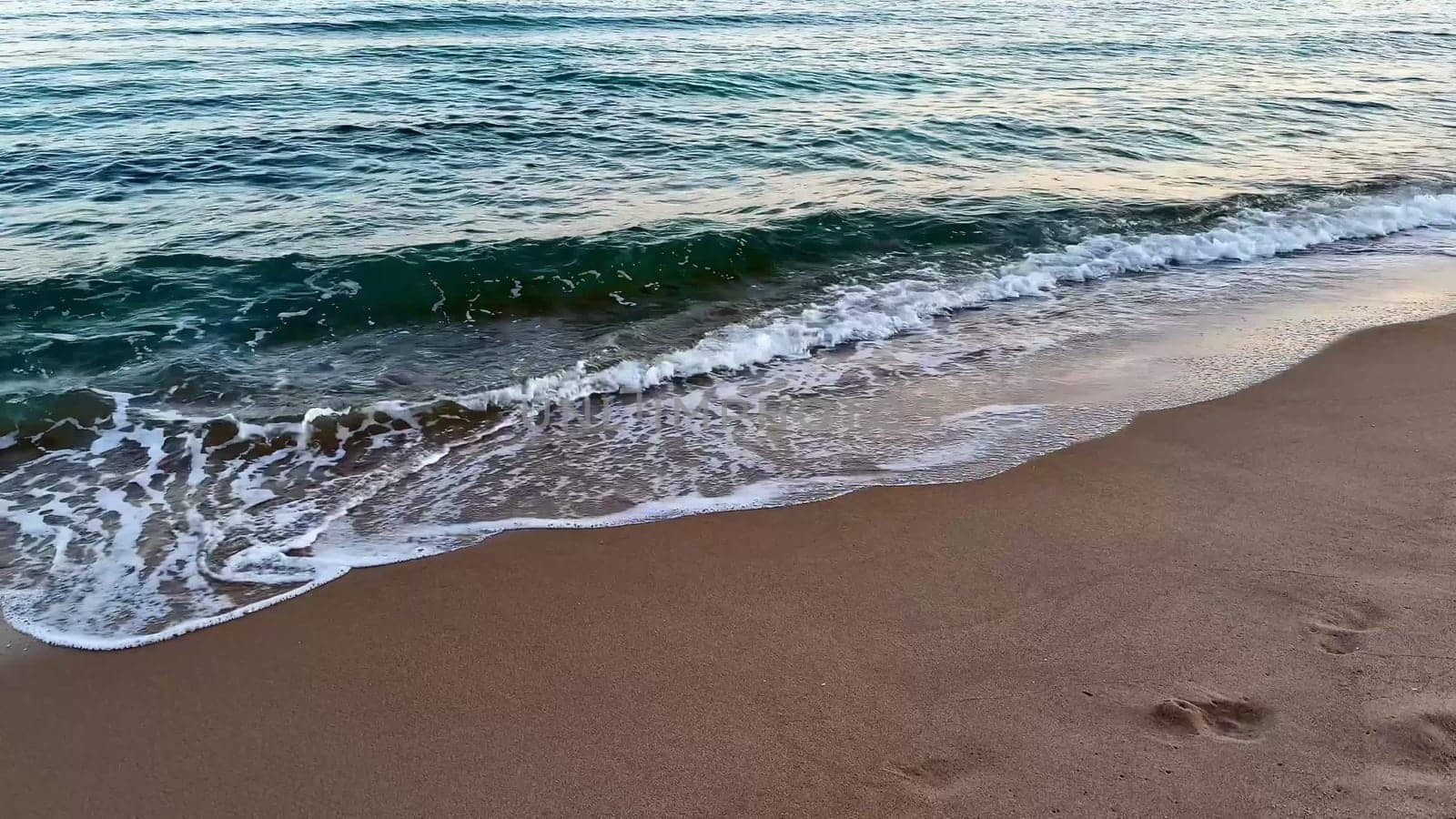 A captivating beach scene unfolds with gentle waves gradually washing ashore at enchanting twilight hours