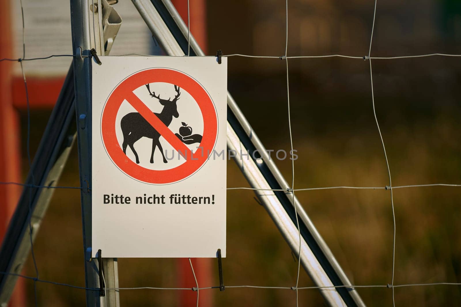 Sign on the fence of a game enclosure with the German inscription Bitte nicht futtern (Please do not feed)