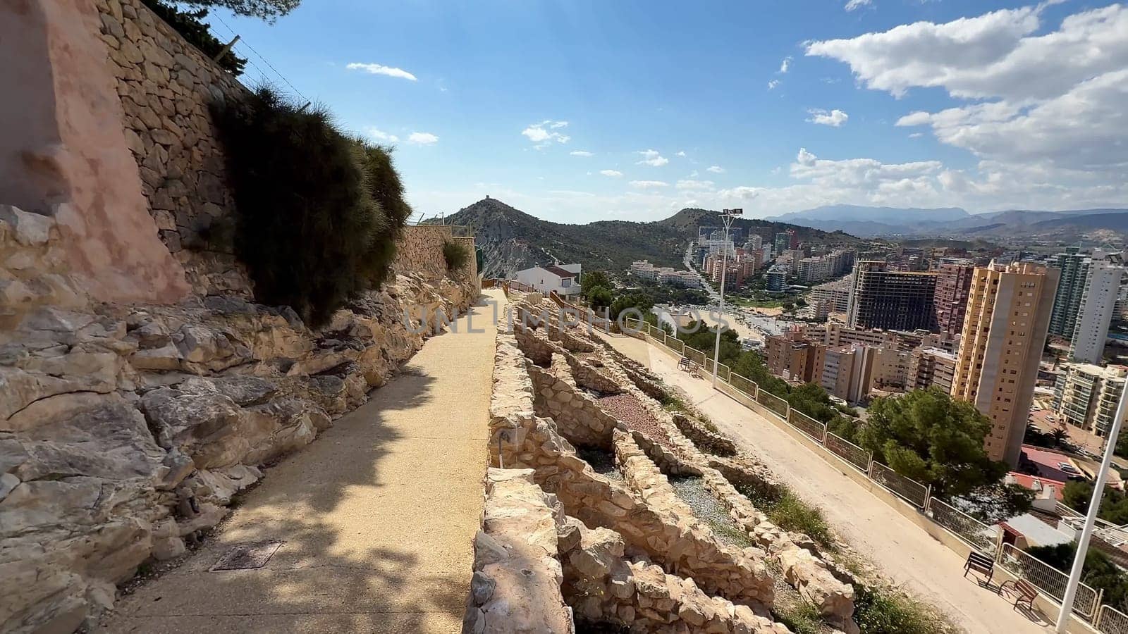 Experience stunning panoramic views of a vibrant city and archaeological site from the scenic hillside