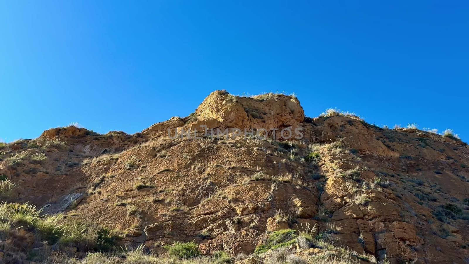 A breathtaking view showcasing impressive rocky formations alongside lush greenery beneath a clear blue sky