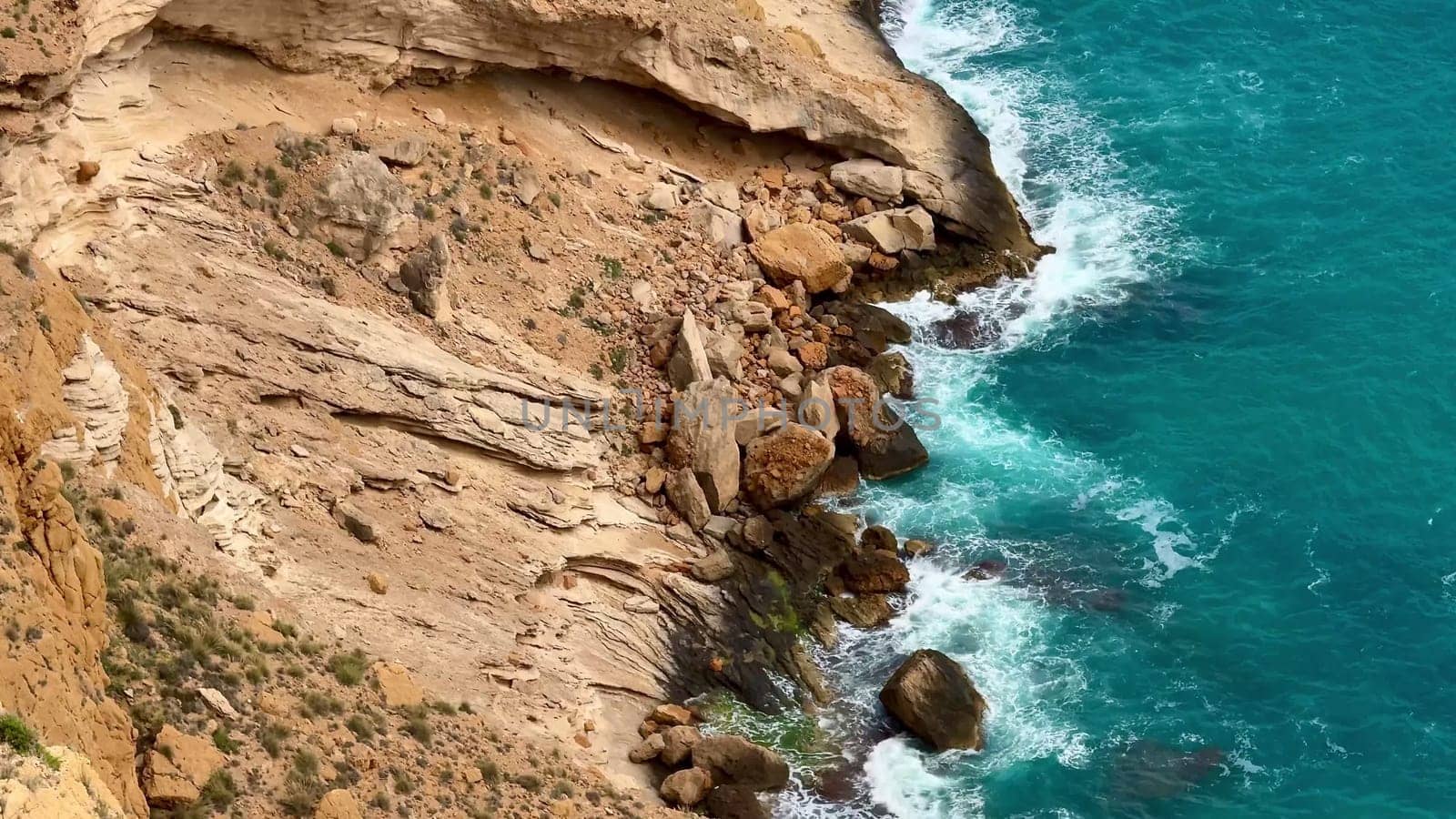 Experience the beauty of nature with this stunning coastal landscape, where waves meet rocky cliffs.