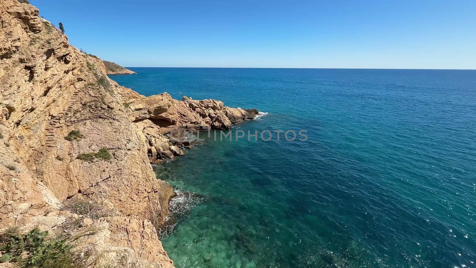 A breathtaking view reveals turquoise waters crashing against rugged cliffs within this truly serene coastal landscape