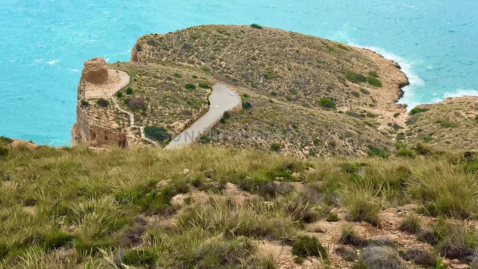 Enjoy stunning coastal views while walking a winding path along the rocky terrain by the vibrant blue sea