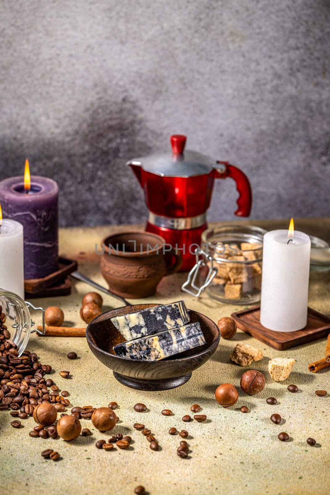Marble cheese, coffee beans, macadamia nuts, brown sugar, cinnamon sticks, candles, and moka pot create a cozy atmosphere
