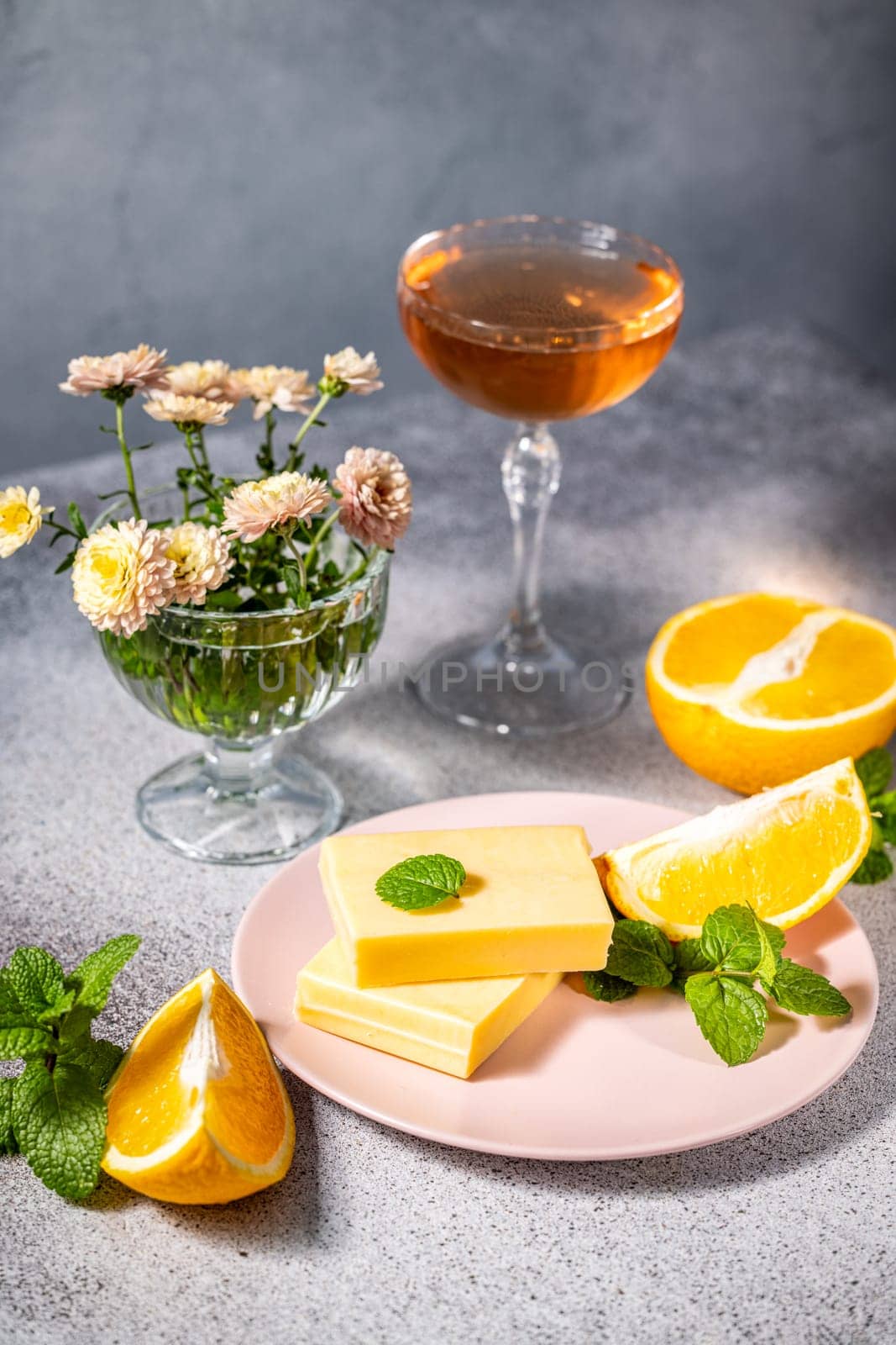 Gourmet orange flavored cheese dessert served with orange slices, mint, and a glass of wine, creating a sophisticated culinary scene