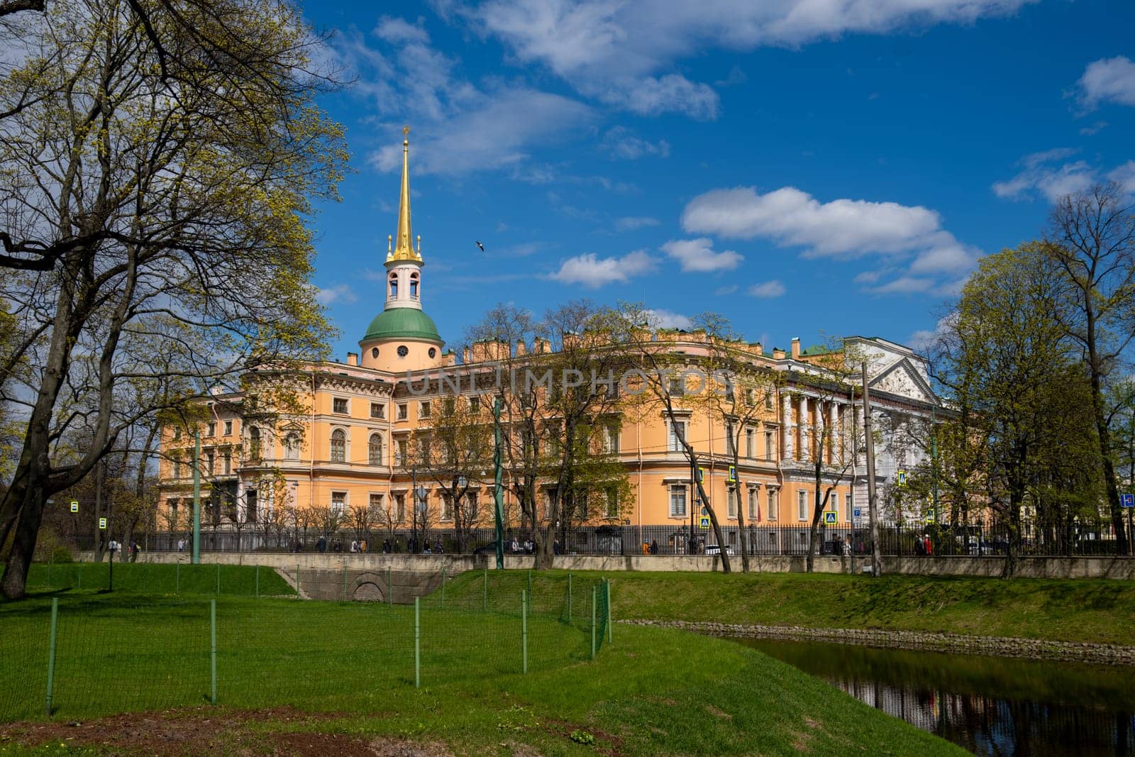 Saint Petersburg, Russia - 02.05.25. Beautiful historical Mikhailovsky Castle surrounded by lush greenery and trees in the park.