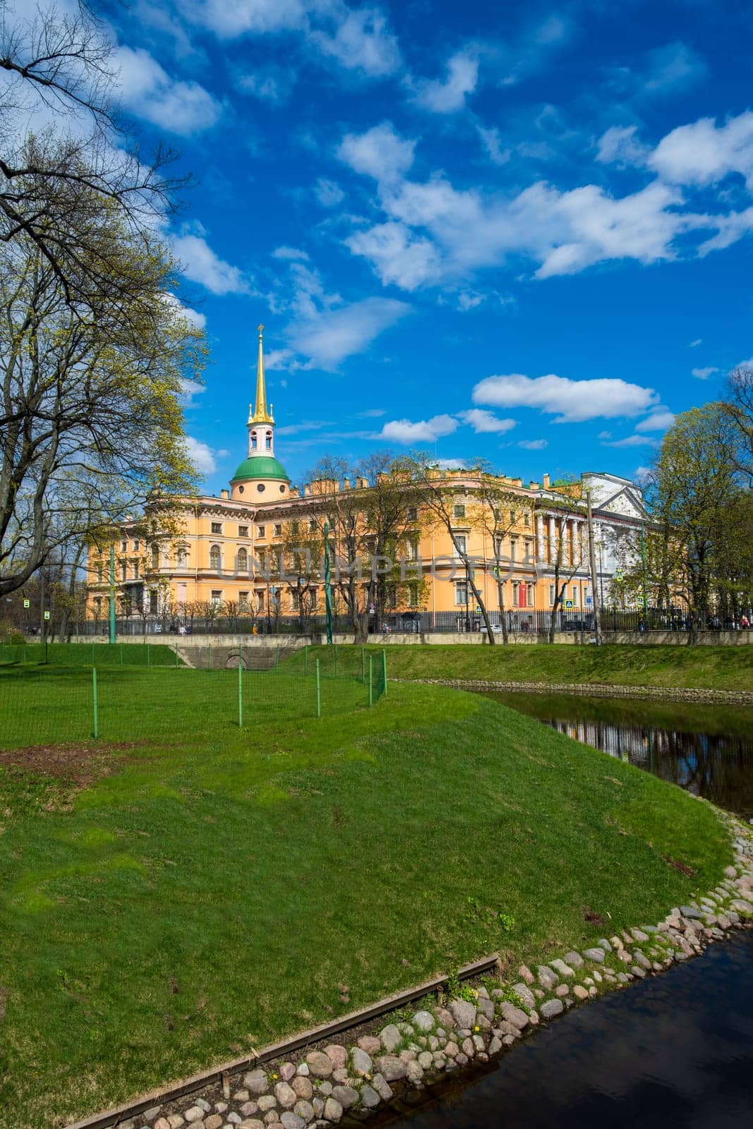 Saint Petersburg, Russia - 02.05.25. Beautiful historical Mikhailovsky Castle surrounded by lush greenery and trees in the park.