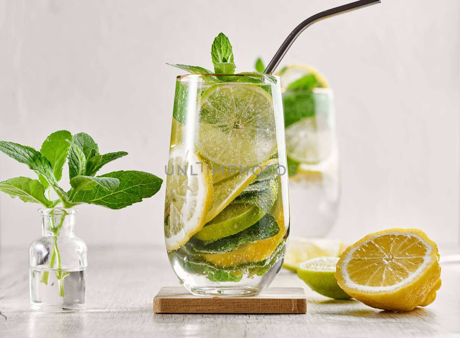 Summer drink with lime and mint. Cold drink, non-alcoholic mojito or lemonade, garnished with fresh mint sprigs and citrus slices. 