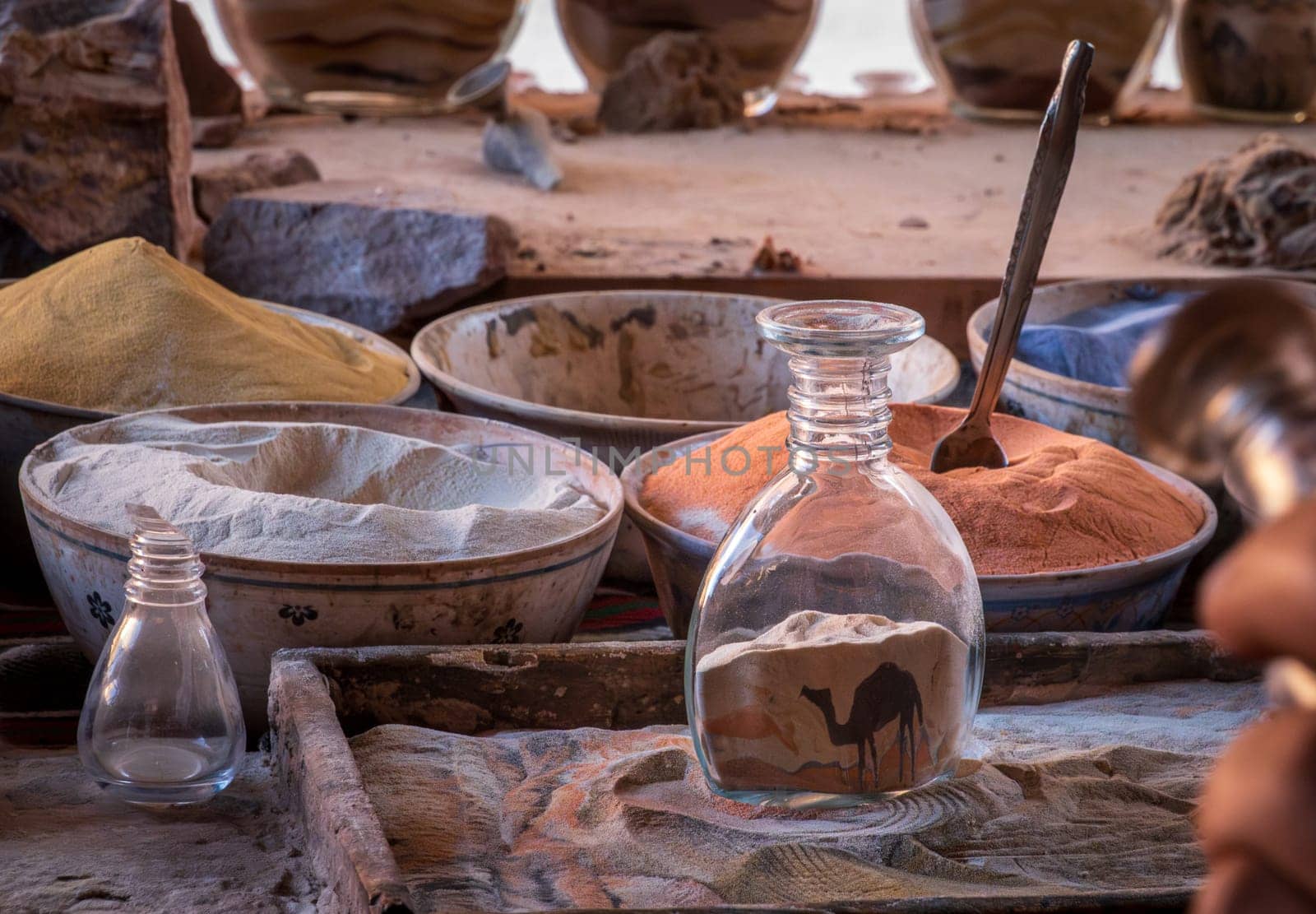 A skilled artisan meticulously crafting a colorful sand bottle souvenir in the ancient city of Petra