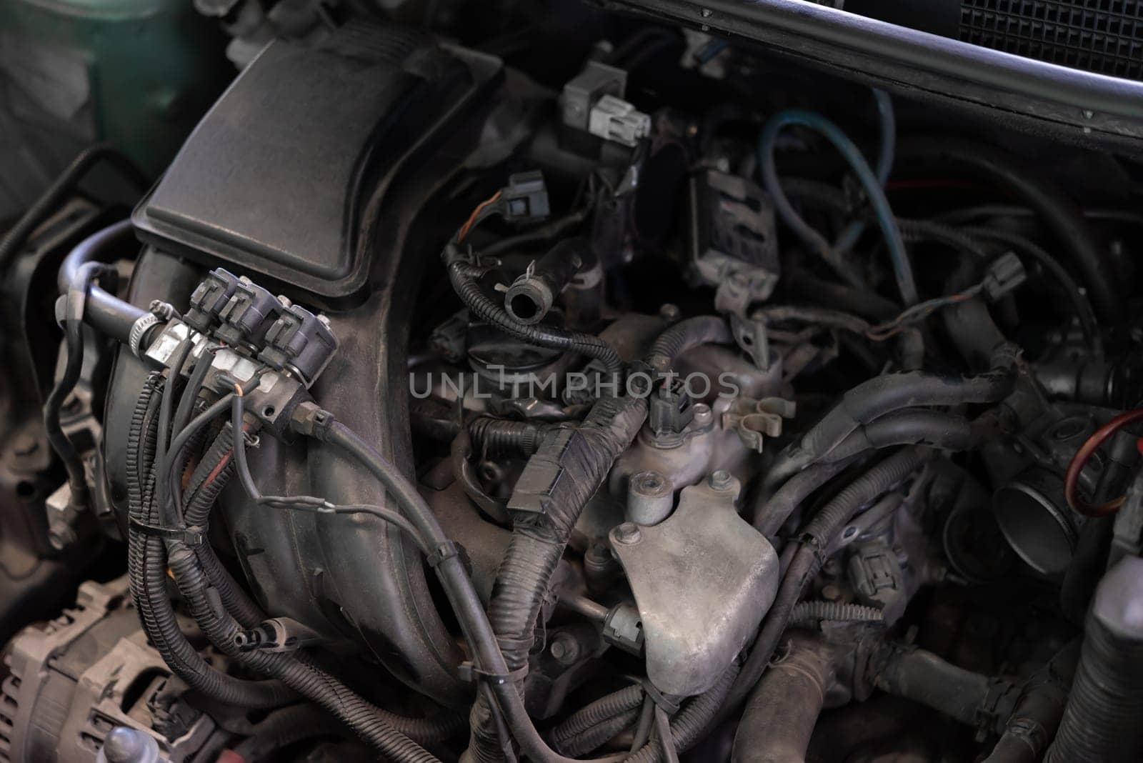 Car mechanic drain the old lubricant engine oil at car garage for changing the oil in a car engine