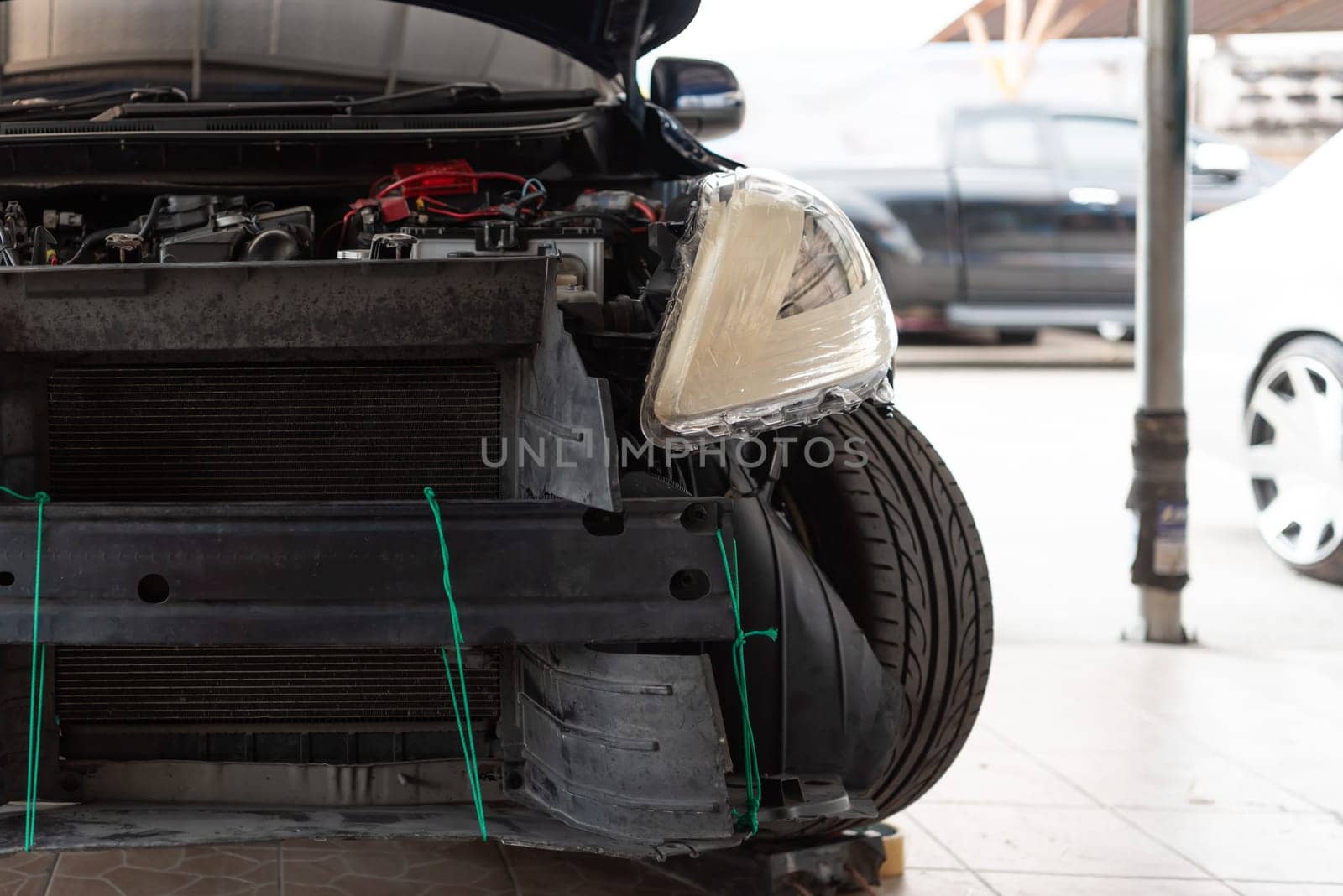 Denter or car mechanic serviceman check and fix body work and fiber bumper body part for fix and repair problem at car garage or repair shop