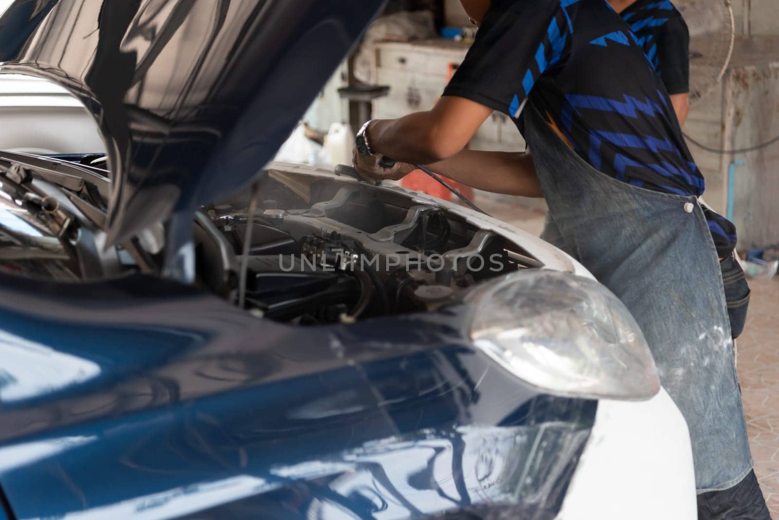 Denter or car mechanic serviceman check and fix body work and fiber bumper body part for fix and repair problem at car garage or repair shop
