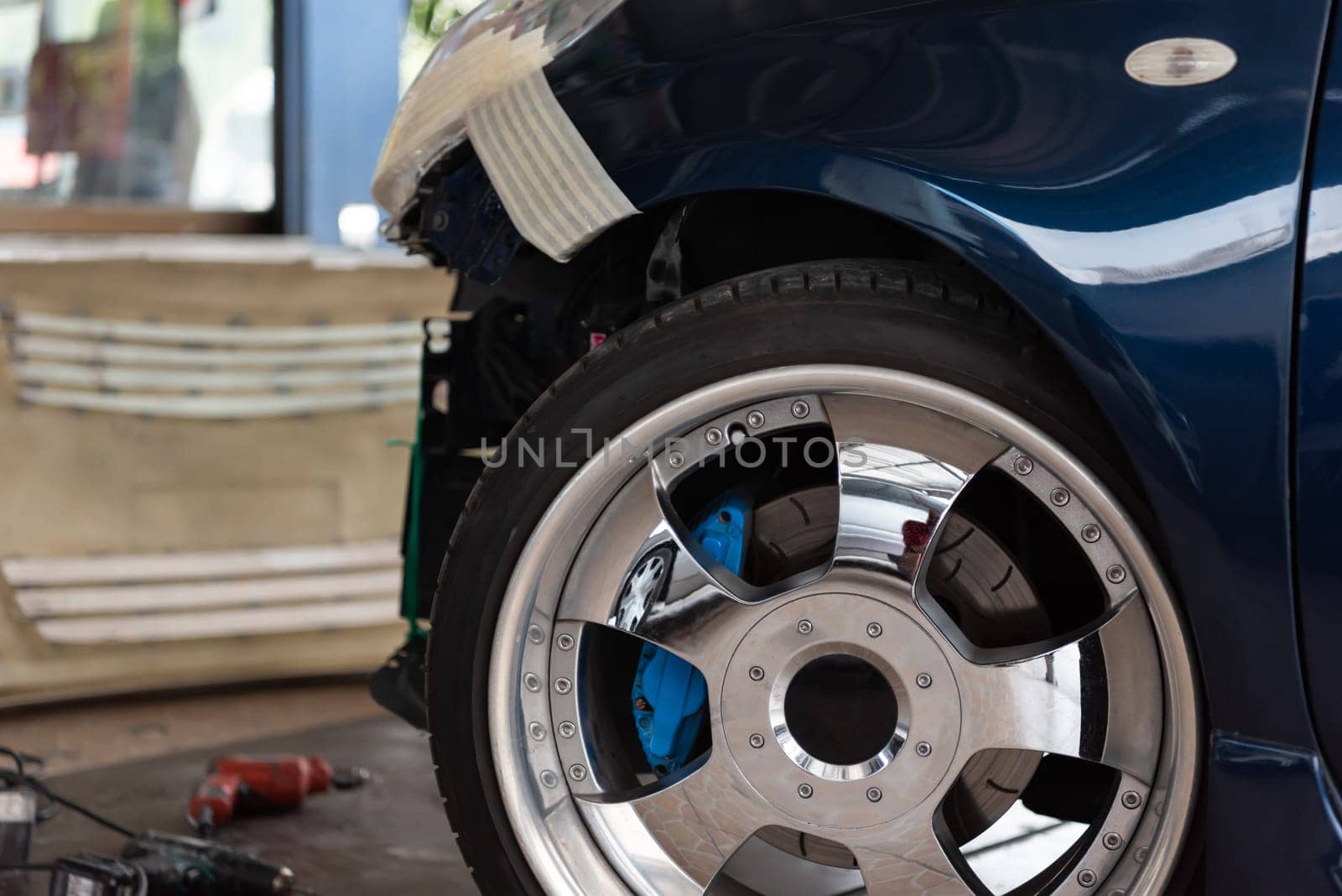 Denter or car mechanic serviceman check and fix body work and fiber bumper body part for fix and repair problem at car garage or repair shop