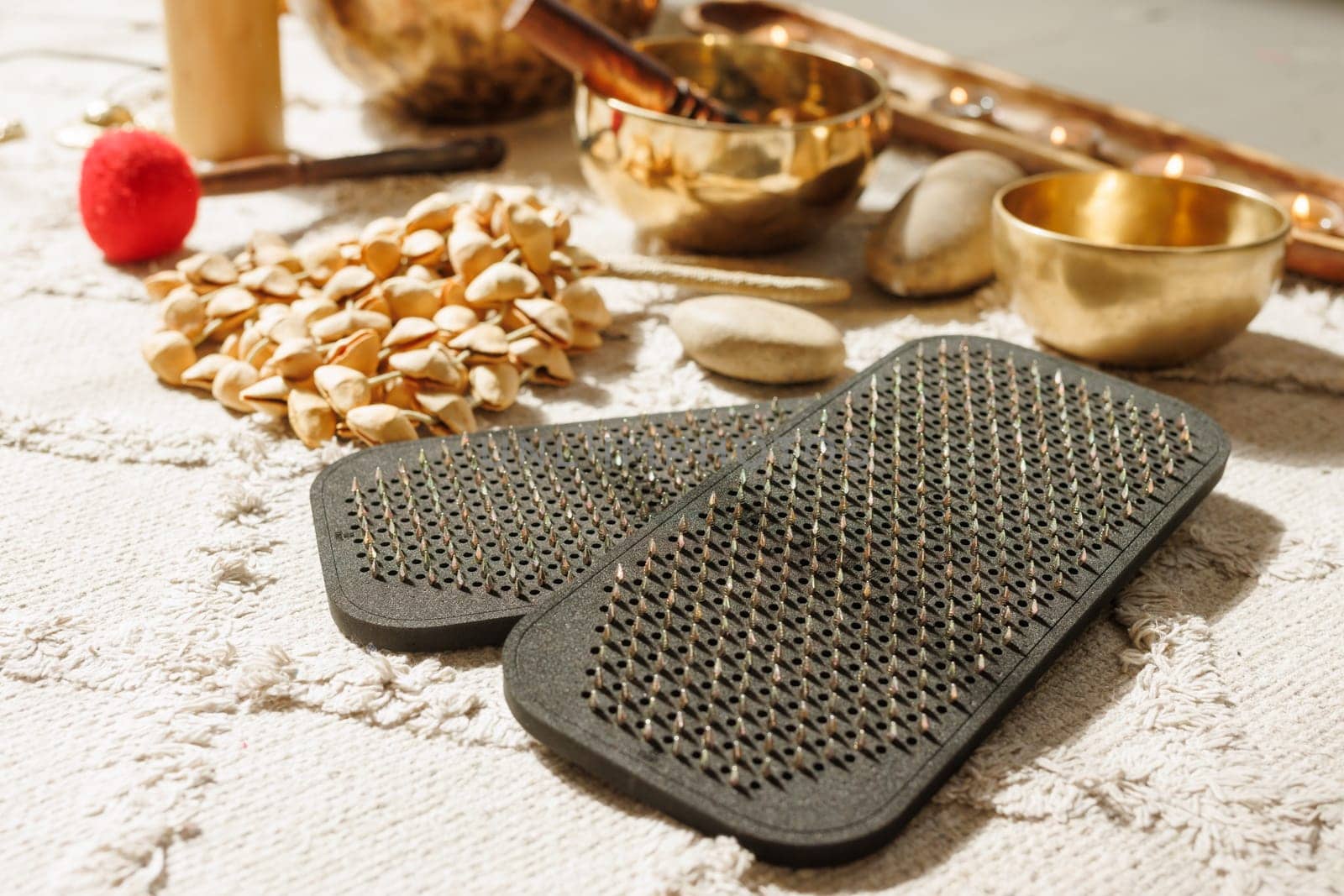 Close up of Sadhu meditation nail board with spiritual objects, singing bowls and healing tools in warm light.