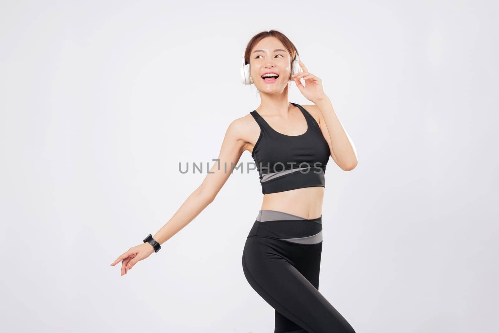 Dance fuels her energy as she listens to her playlist while staying active. With every beat, her body responds and she begins to dance again with joy and focus. isolated studio white background